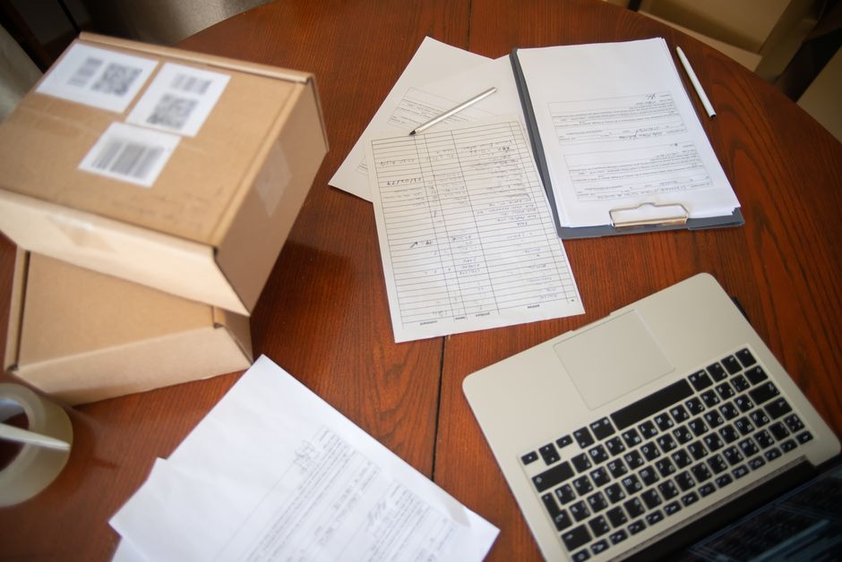 Invoices and paperwork spread across a wooden desk