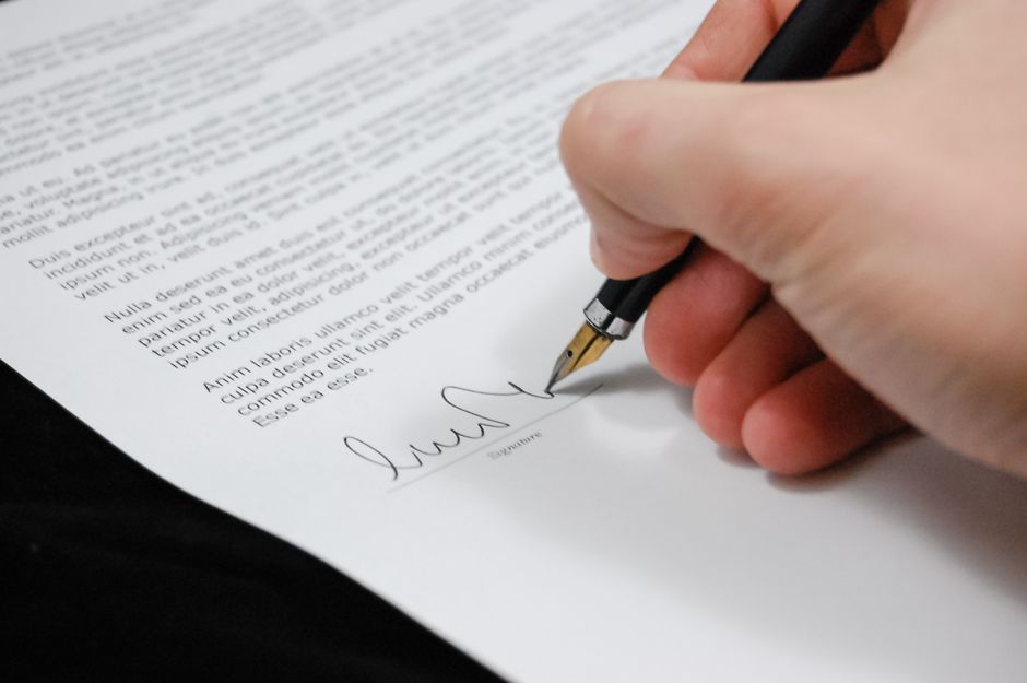Hand signing a contract with a fountain pen