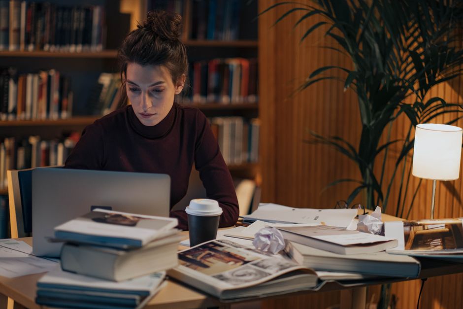 Student working through books and notes at a desk